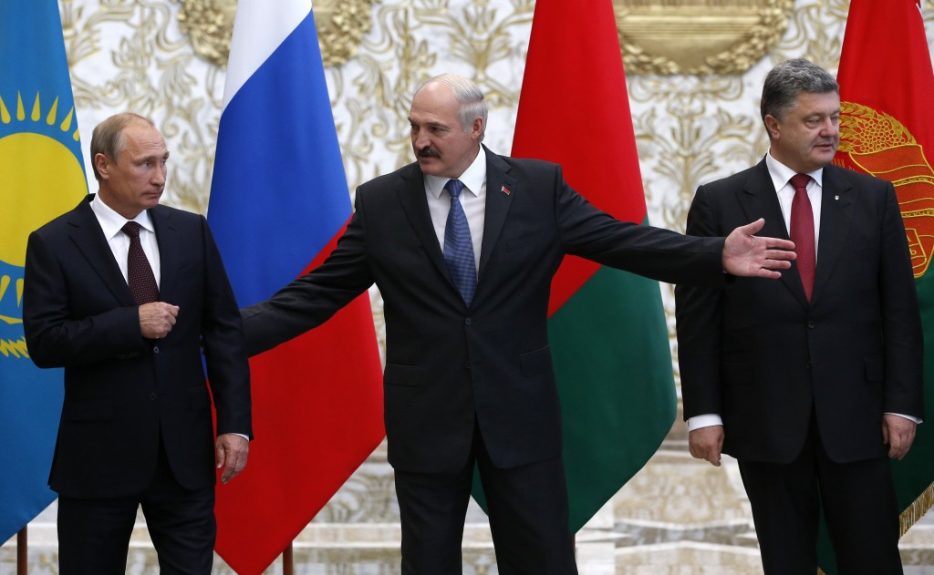 Russia's President Putin, Belarus' President Lukashenko and Ukraine's President Poroshenko react while posing for a family photo during their meeting in Minsk
